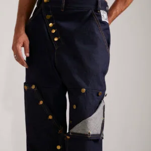 Detalle de los botones a presión y etiqueta interactiva del pantalón Utility Jeans, destacando como referente en marcas de ropa con codigo qr.